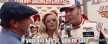 Gif from Talladega Nights movie. Ricky Bobby is saying to a reporter "If you ain't first, you're last." A blonde woman in sunglasses nods next to him.